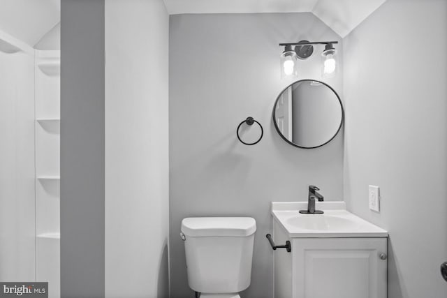 bathroom with vanity, vaulted ceiling, and toilet