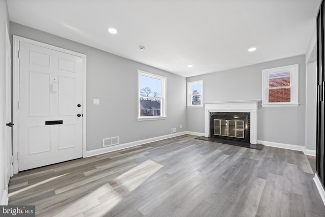 unfurnished living room with a fireplace and light hardwood / wood-style floors