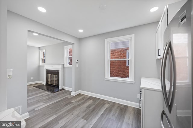 clothes washing area with plenty of natural light, a fireplace, and light hardwood / wood-style flooring