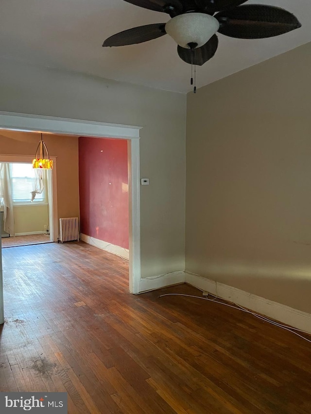 unfurnished room featuring radiator, hardwood / wood-style floors, and ceiling fan