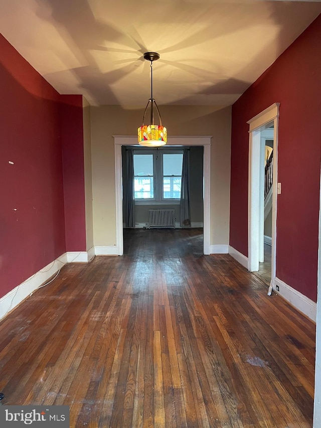 unfurnished dining area with radiator and dark hardwood / wood-style floors