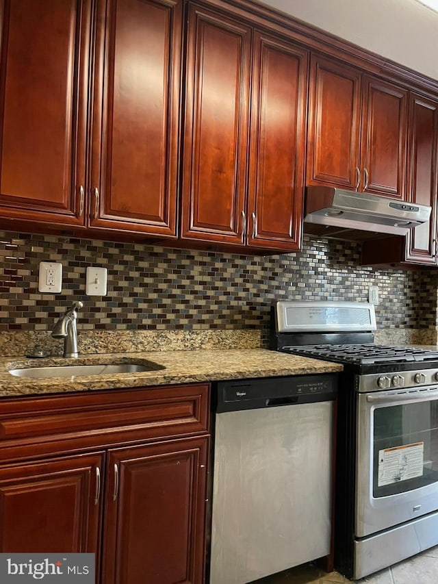 kitchen with appliances with stainless steel finishes, light stone countertops, sink, and decorative backsplash