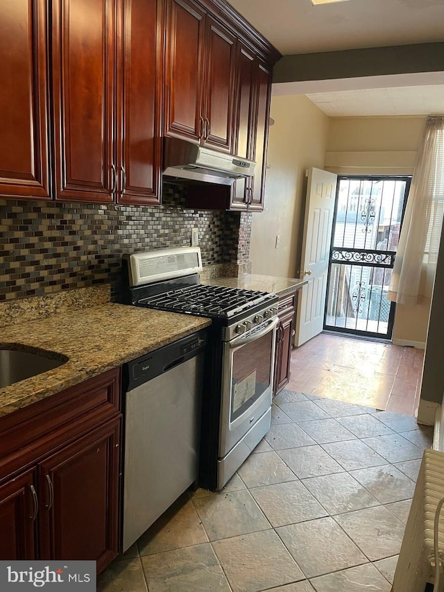 kitchen with stainless steel appliances, tasteful backsplash, light stone countertops, and light tile patterned flooring