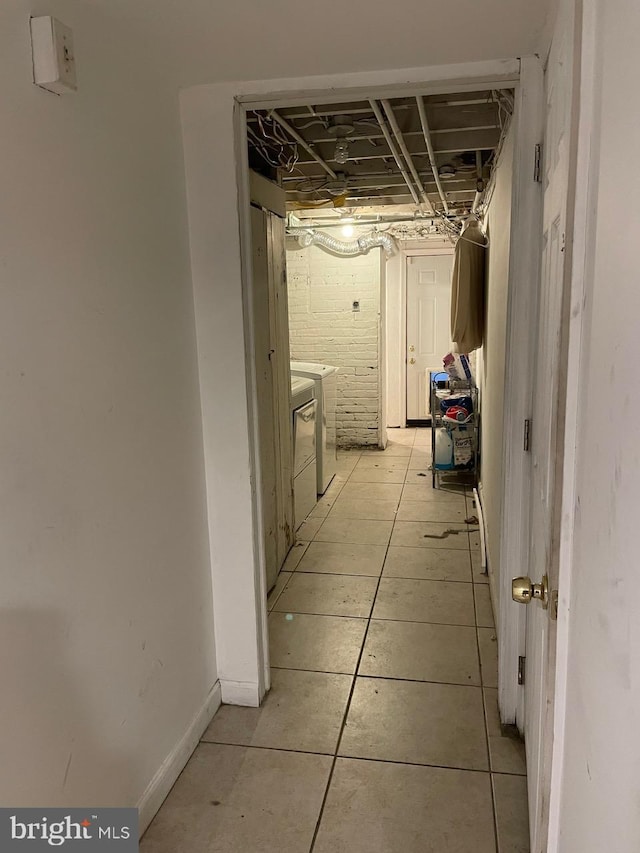 corridor featuring light tile patterned floors and washer and dryer