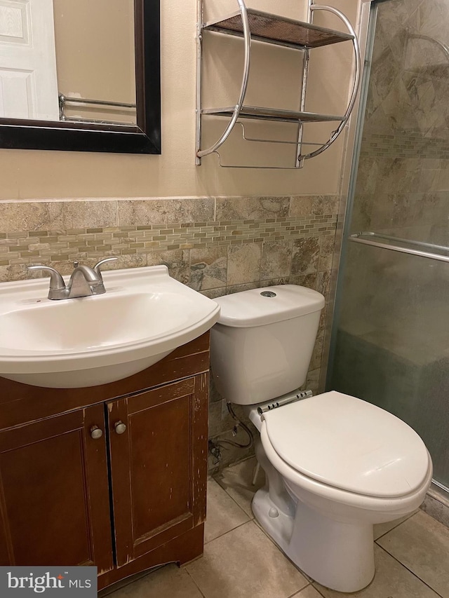 bathroom with vanity, tile walls, tile patterned floors, and toilet