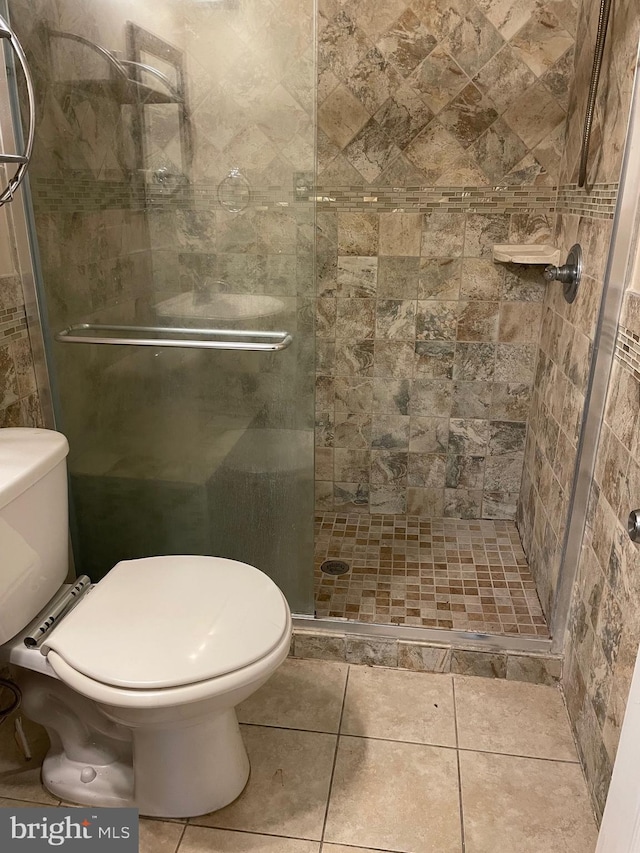 bathroom featuring walk in shower, tile patterned floors, and toilet