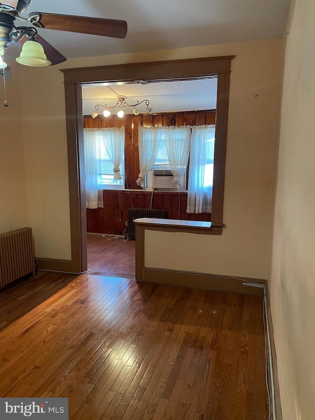 empty room with radiator heating unit and wood-type flooring