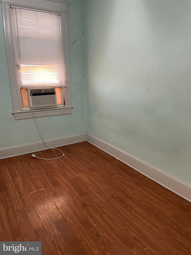 empty room featuring cooling unit and hardwood / wood-style floors