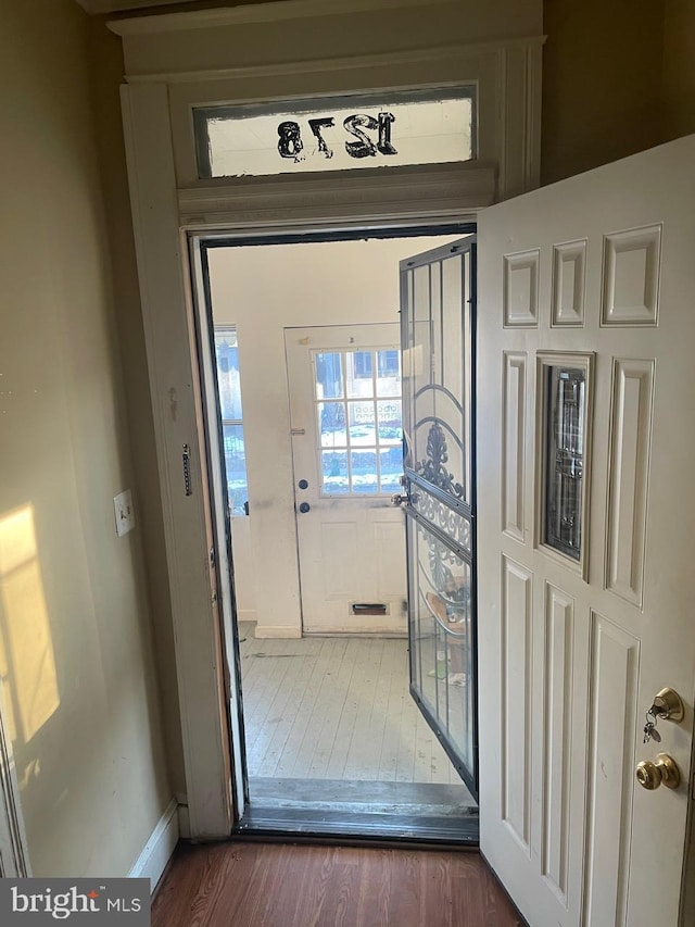 doorway featuring dark wood-type flooring and baseboard heating