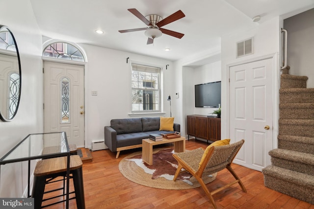 living room with hardwood / wood-style flooring, a baseboard heating unit, and ceiling fan