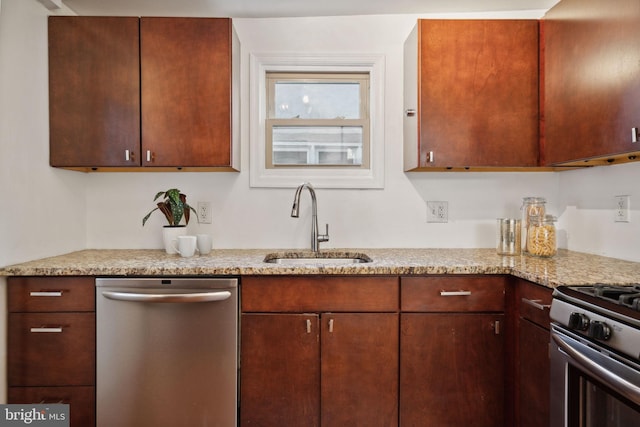 kitchen with light stone counters, appliances with stainless steel finishes, and sink