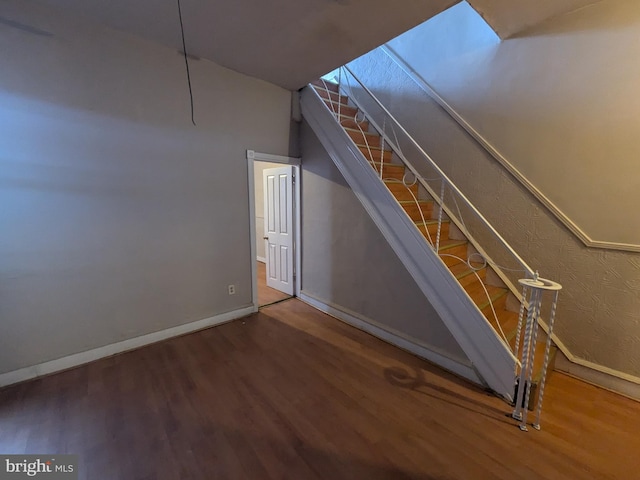 staircase with hardwood / wood-style floors