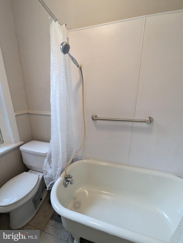 bathroom featuring tile patterned floors, shower / bath combination with curtain, and toilet