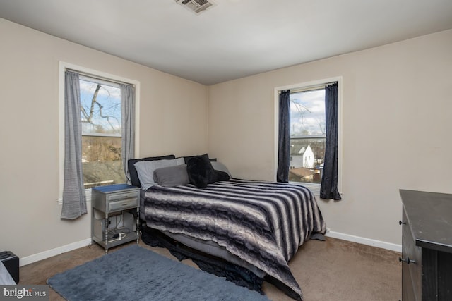 bedroom featuring multiple windows and dark colored carpet