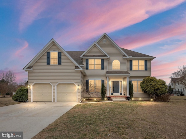 traditional-style house with concrete driveway, a shingled roof, a lawn, and an attached garage