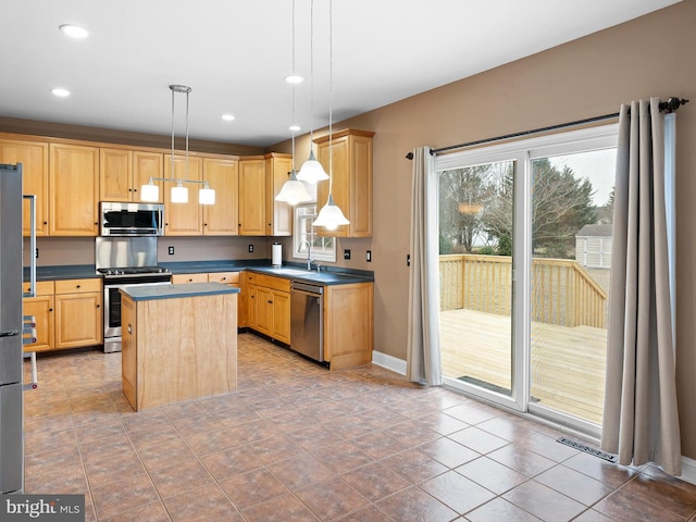 kitchen with stainless steel appliances, a center island, light brown cabinetry, dark countertops, and decorative light fixtures