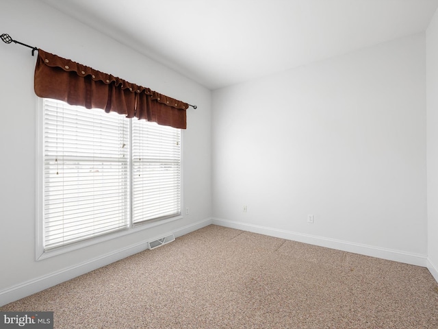 carpeted empty room featuring visible vents and baseboards