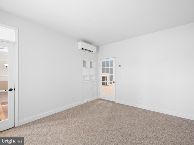 spare room with carpet, a wall mounted air conditioner, and baseboards