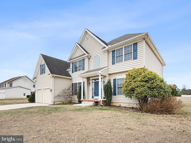 traditional-style house featuring a garage, a front yard, and concrete driveway