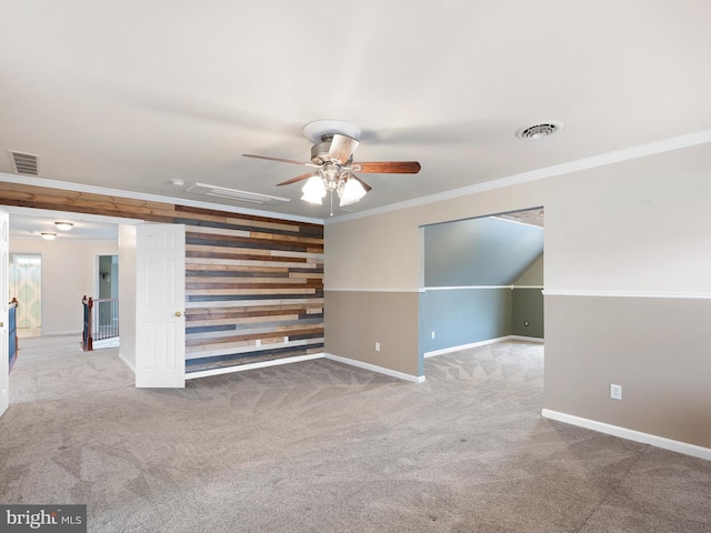 additional living space with carpet floors, visible vents, wooden walls, and baseboards