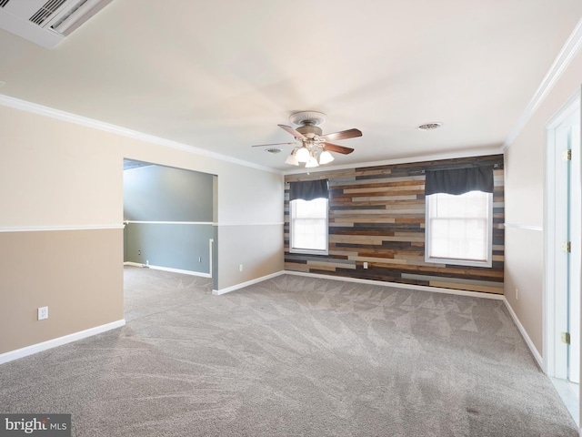 empty room featuring carpet, visible vents, crown molding, and baseboards