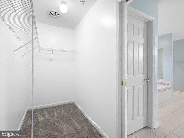 walk in closet with light tile patterned floors, light carpet, and visible vents