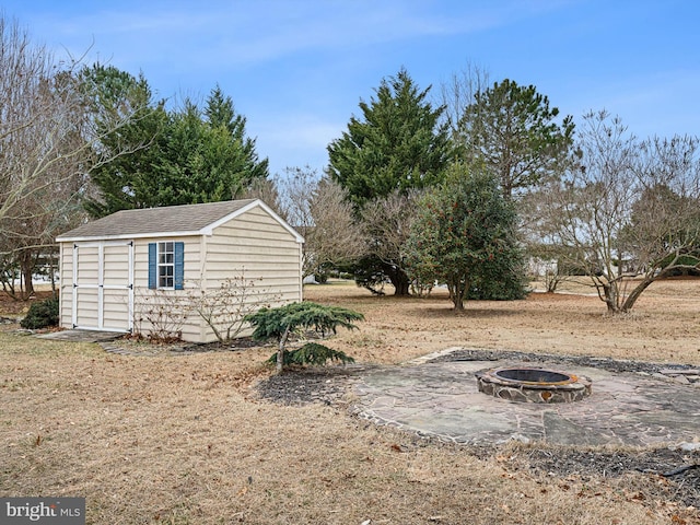 view of yard with a fire pit, a storage shed, and an outdoor structure