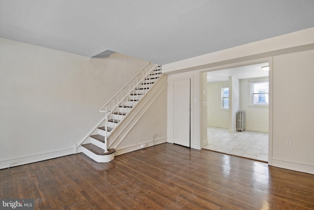 interior space with hardwood / wood-style flooring and radiator heating unit