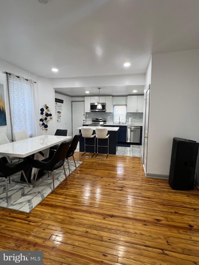 dining area featuring plenty of natural light, sink, and light wood-type flooring