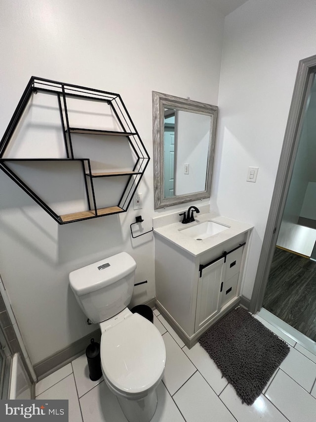 bathroom featuring tile patterned flooring, vanity, and toilet