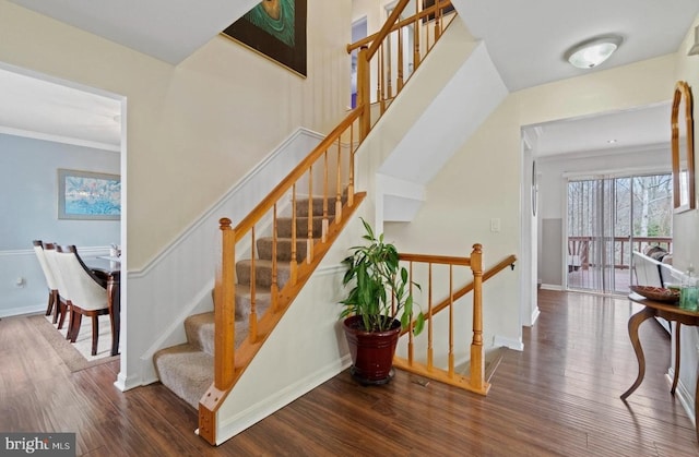 stairway with crown molding and hardwood / wood-style floors