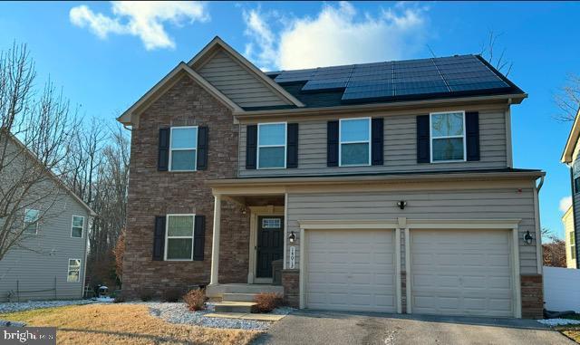 view of front of home with a garage and solar panels