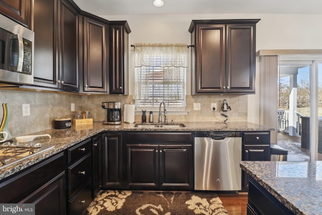 kitchen featuring light stone counters, sink, plenty of natural light, and stainless steel appliances