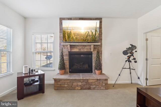 carpeted living room with a wealth of natural light and a fireplace