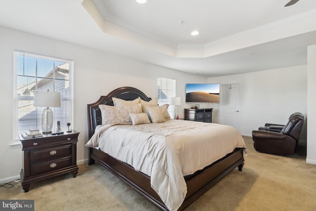 bedroom with light carpet, a tray ceiling, and multiple windows