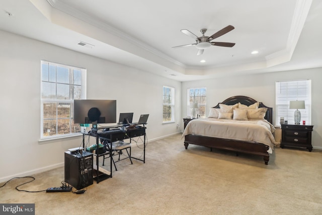 bedroom with multiple windows, light colored carpet, ceiling fan, and a tray ceiling