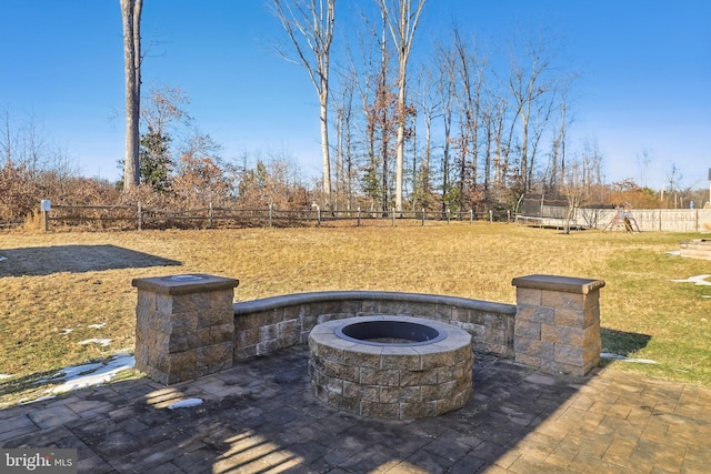 view of patio with a playground, a trampoline, and an outdoor fire pit