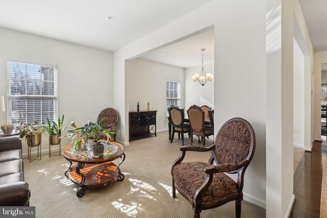 living area featuring carpet flooring and an inviting chandelier