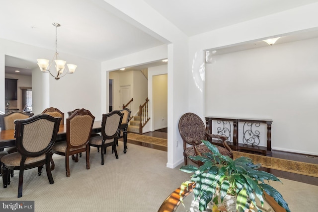 carpeted dining room with a notable chandelier