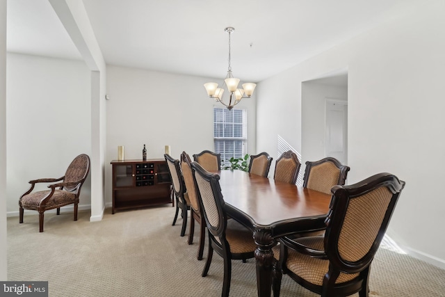 dining room featuring light carpet and a notable chandelier