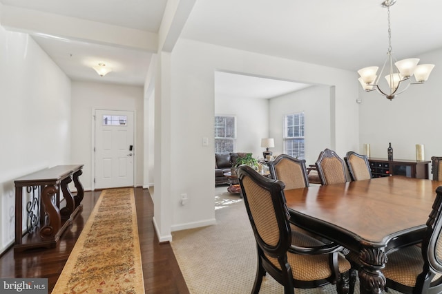 dining area featuring beamed ceiling and a chandelier