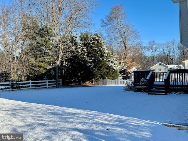 snowy yard featuring a deck