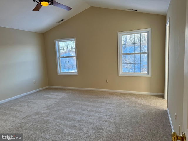 carpeted empty room with a wealth of natural light, ceiling fan, and vaulted ceiling