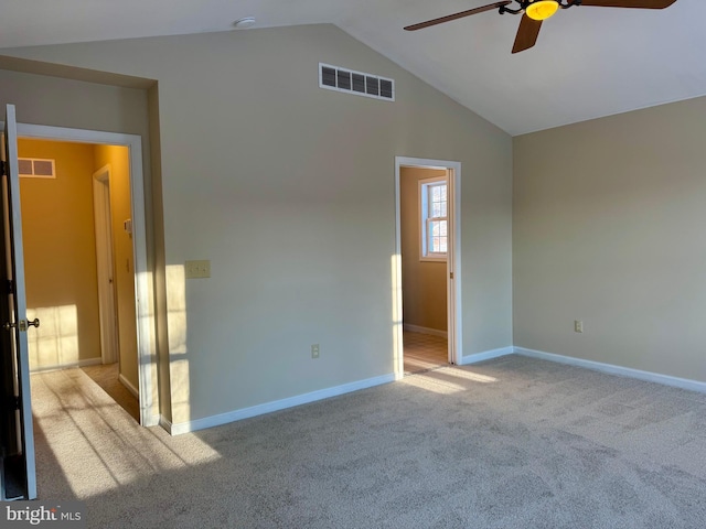 carpeted spare room with lofted ceiling and ceiling fan