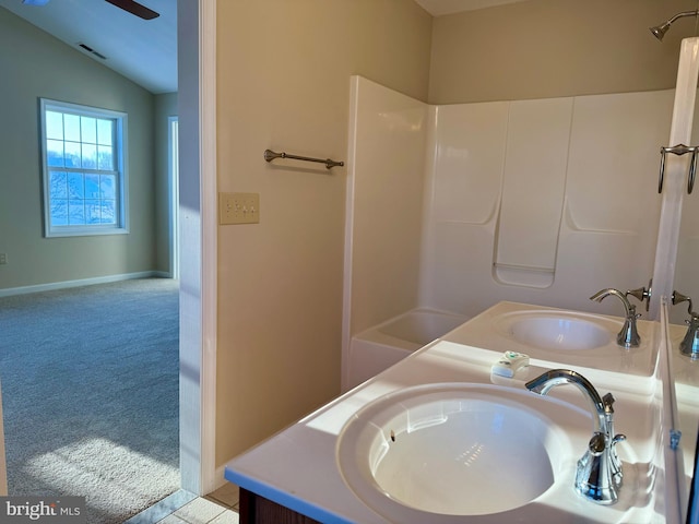 bathroom featuring vanity, vaulted ceiling, and shower / bathtub combination