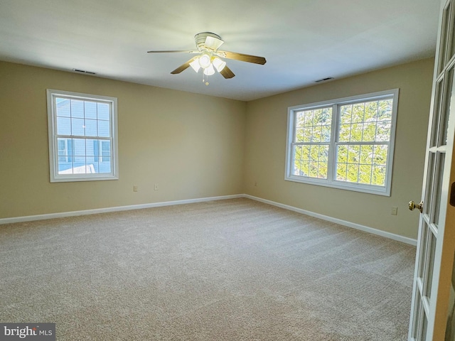 carpeted spare room with ceiling fan and a healthy amount of sunlight