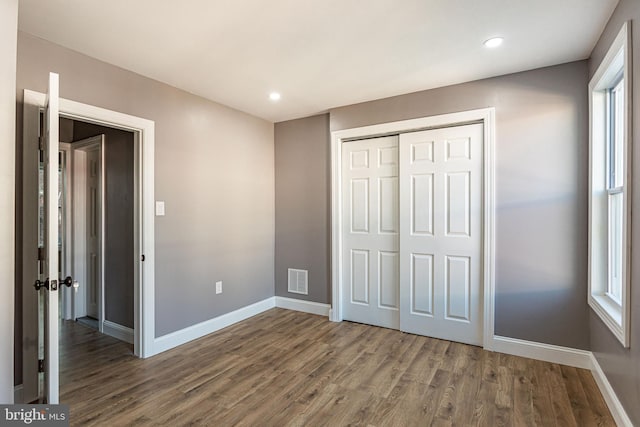 unfurnished bedroom featuring dark hardwood / wood-style floors and a closet