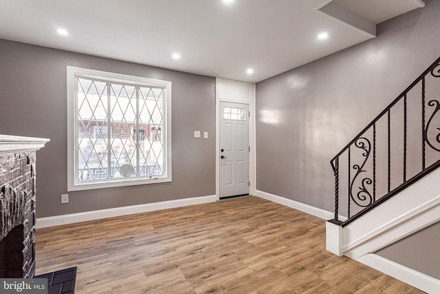 foyer featuring a fireplace and light hardwood / wood-style flooring