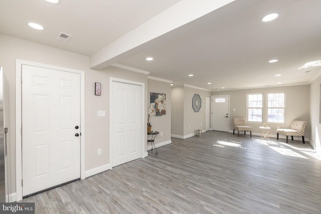 entryway with crown molding and light wood-type flooring