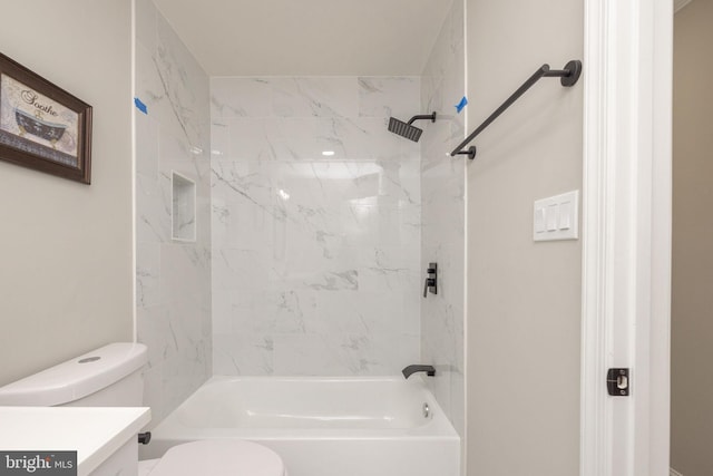 full bathroom featuring vanity, tiled shower / bath combo, and toilet